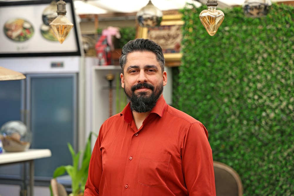 Shop owner in a red shirt